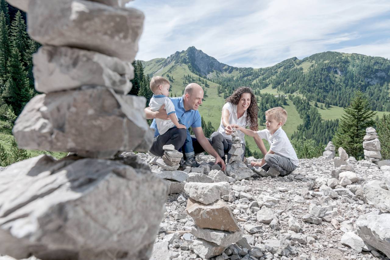 Familie baut Steinmännchen in den Liechtensteiner Alpen