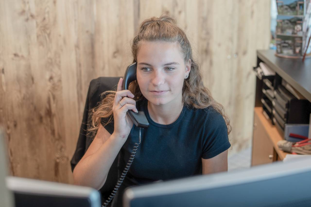 Empfangsmitarbeiterin am Telefon im Familienhotel Gorfion Liechtenstein