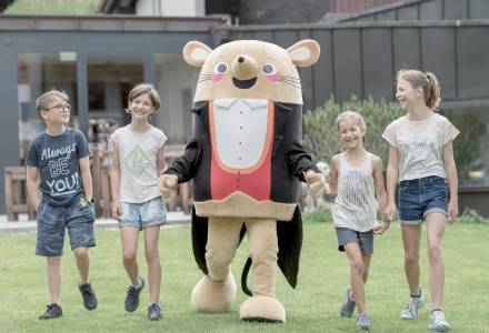 Kinder mit Maskottchen Herr Gorfion vor dem Familienhotel Gorfion Liechtenstein