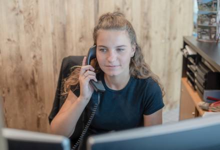 Empfangsmitarbeiterin am Telefon im Familienhotel Gorfion Liechtenstein