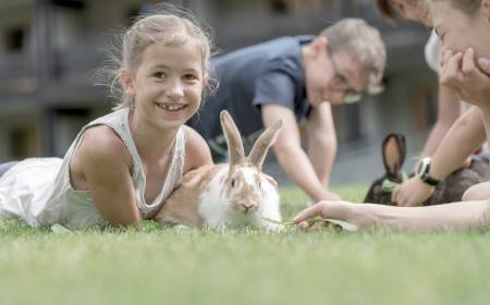 Kinder streicheln Kaninchen im Familienhotel Gorfion in Liechtenstein