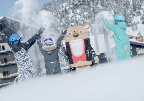 Kinder und Maskottchen Herr Gorfion werfen Schnee in die Luft