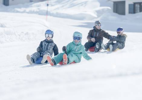 Familie beim Rodeln in Malbun Liechtenstein