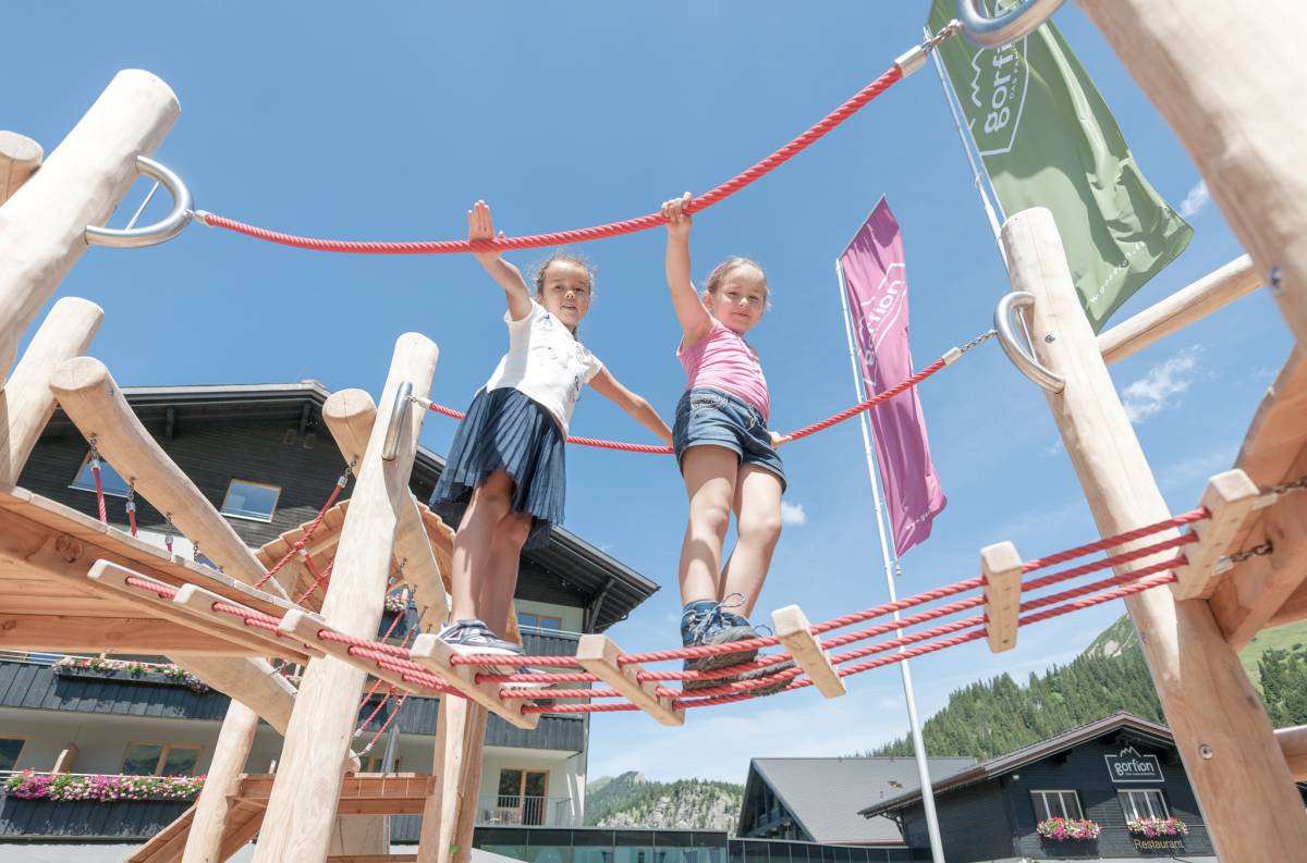 Kinder wippen auf dem Spielplatz im Familienhotel Gorfion in Liechtenstein